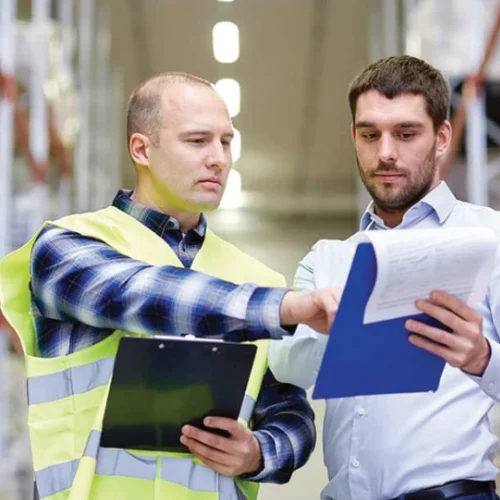 Facility safety manager conducting a workplace safety audit in a manufacturing facility.